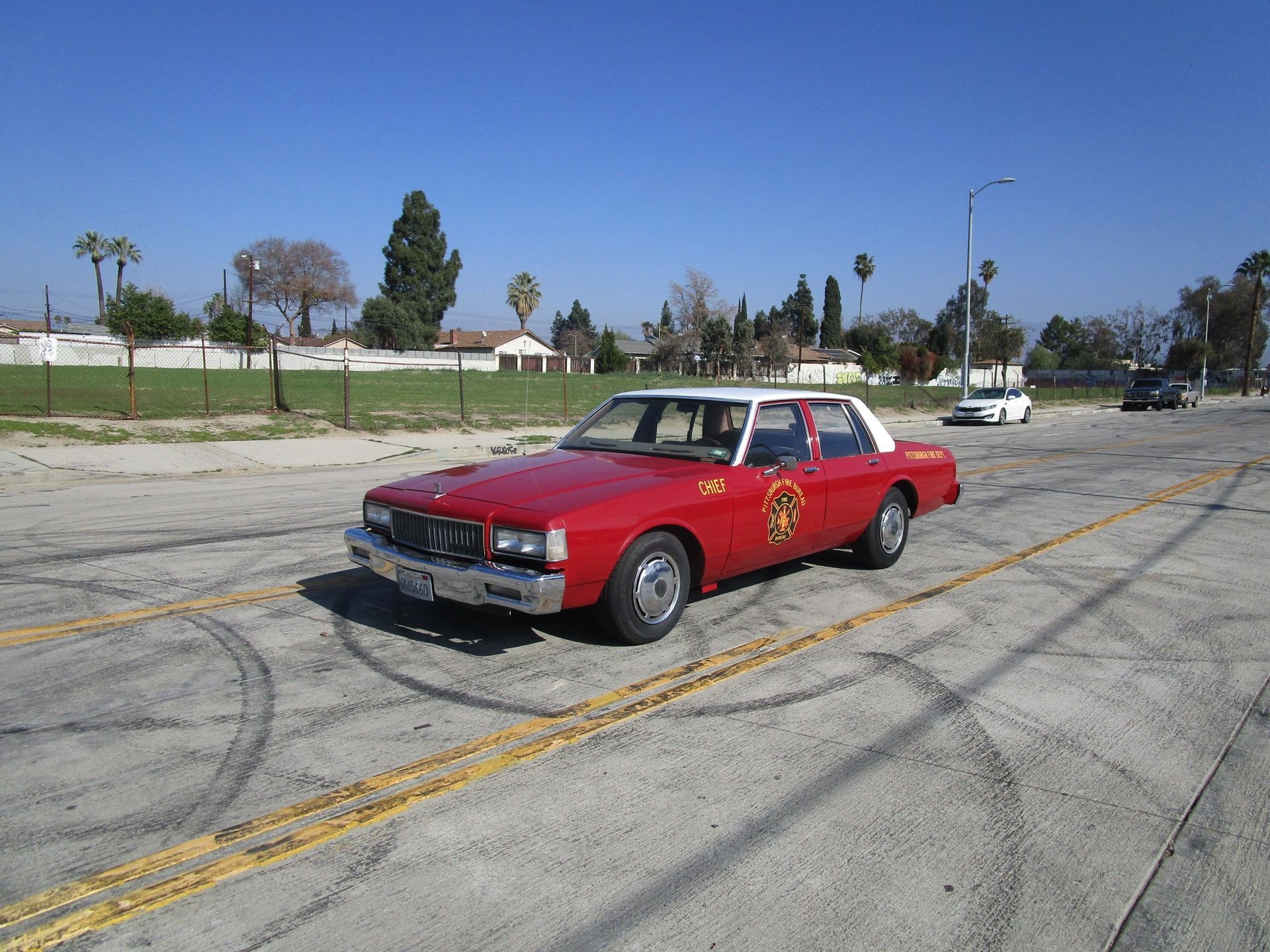 a red car is parked on the side of the road and ready to install a pod rig for film shooting.
