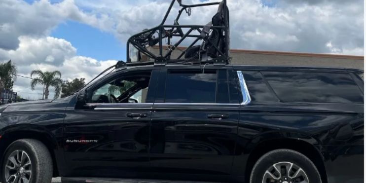 A black SUV with a roof rack, showcasing its robust design and readiness for adventure and dynamic filming scenarios.