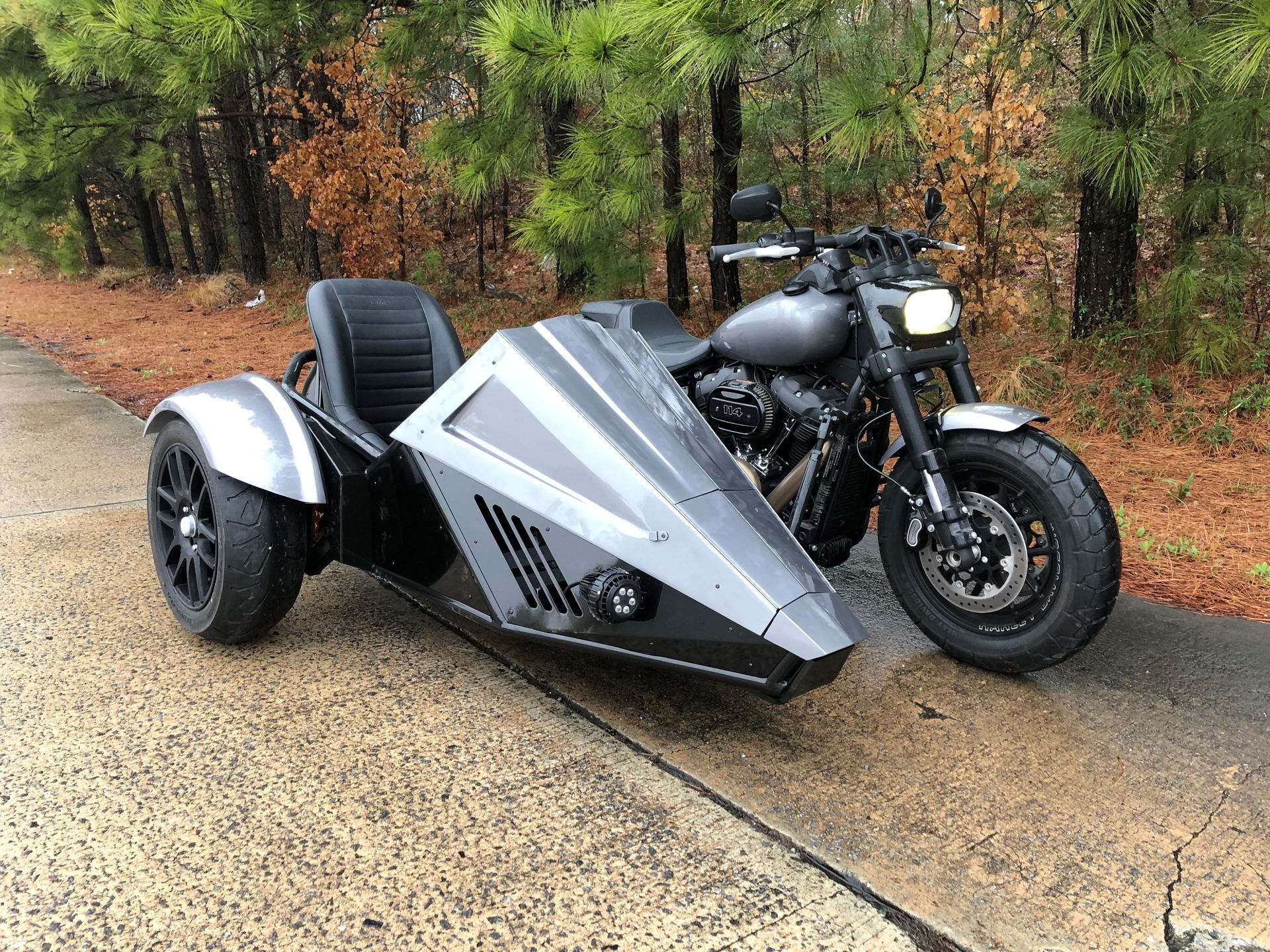 Bad Boys Bike - Black motorcycle with matching sidecar on a wet road. Gray body panels, black wheels, and a single headlight.