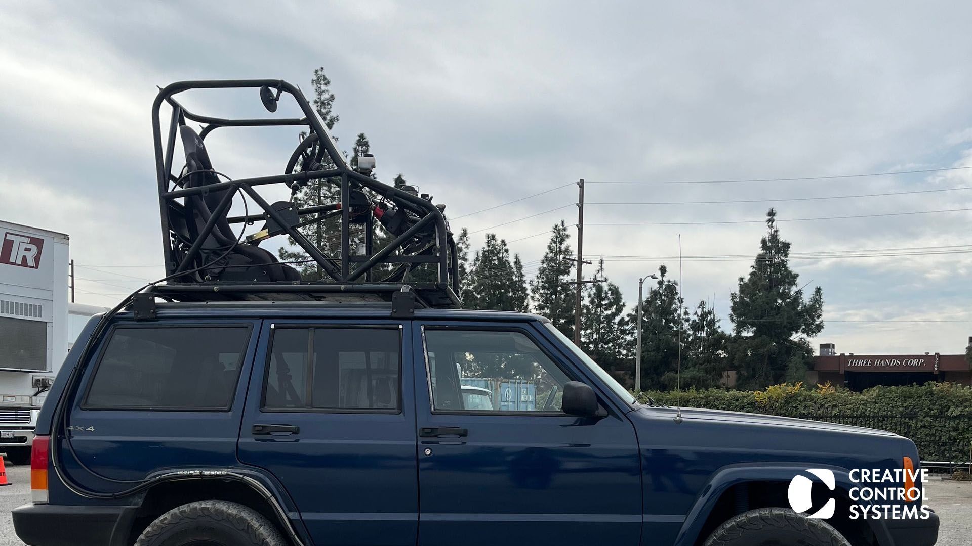 A blue jeep equipped with a bike rack on top, showcasing versatility for outdoor adventures and filming scenarios.