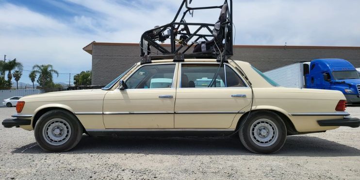 A beige Mercedes with a roof rack, showcasing enhanced stability for dynamic filming in various driving conditions.