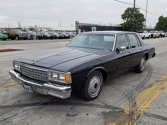 a black car is parked in a parking lot  and ready to install a pod rig for film shooting.