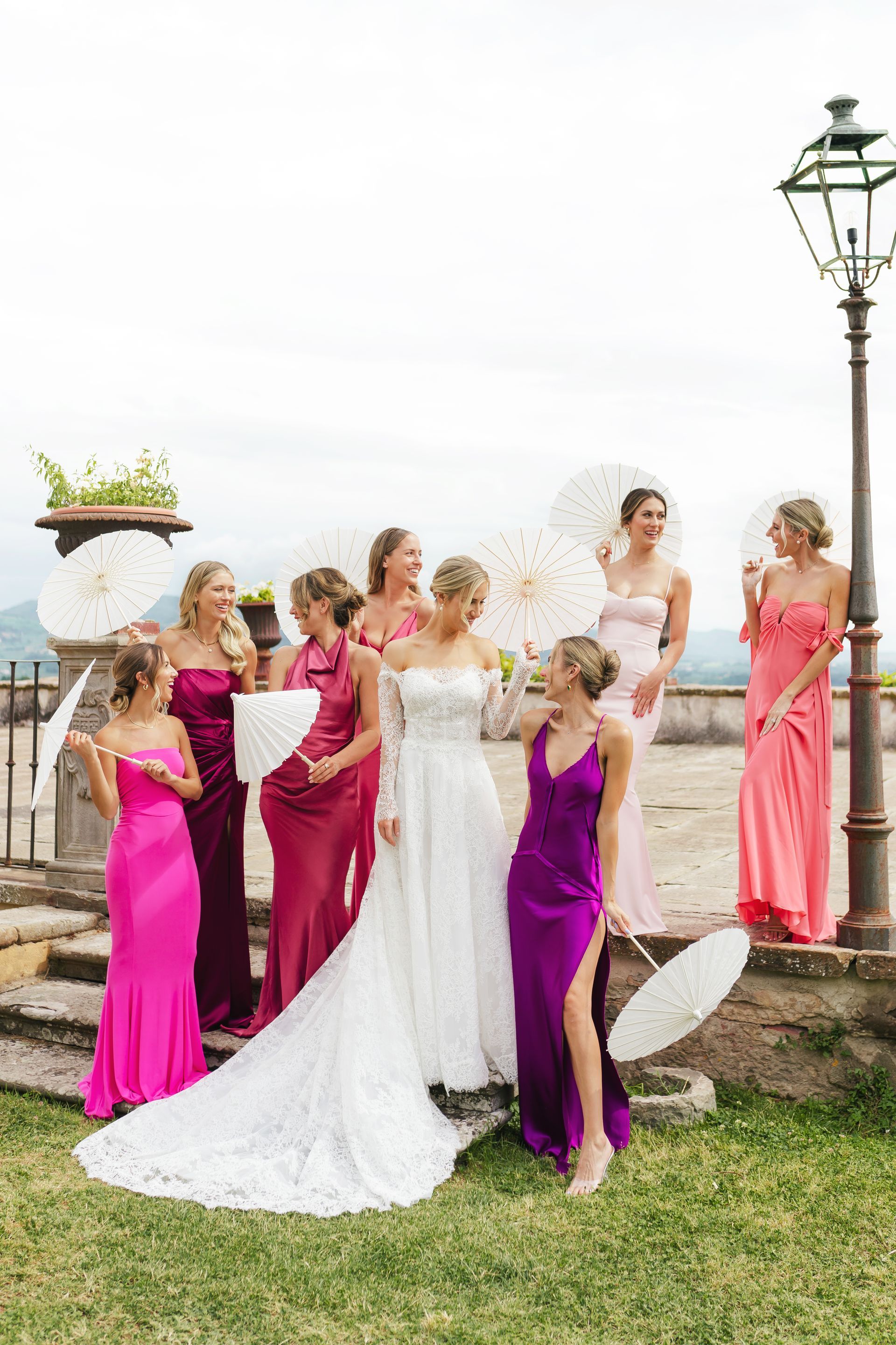 Bride with bridesmaids holding parasols at Villa di Maiano Tuscany during luxury wedding captured in editorial style