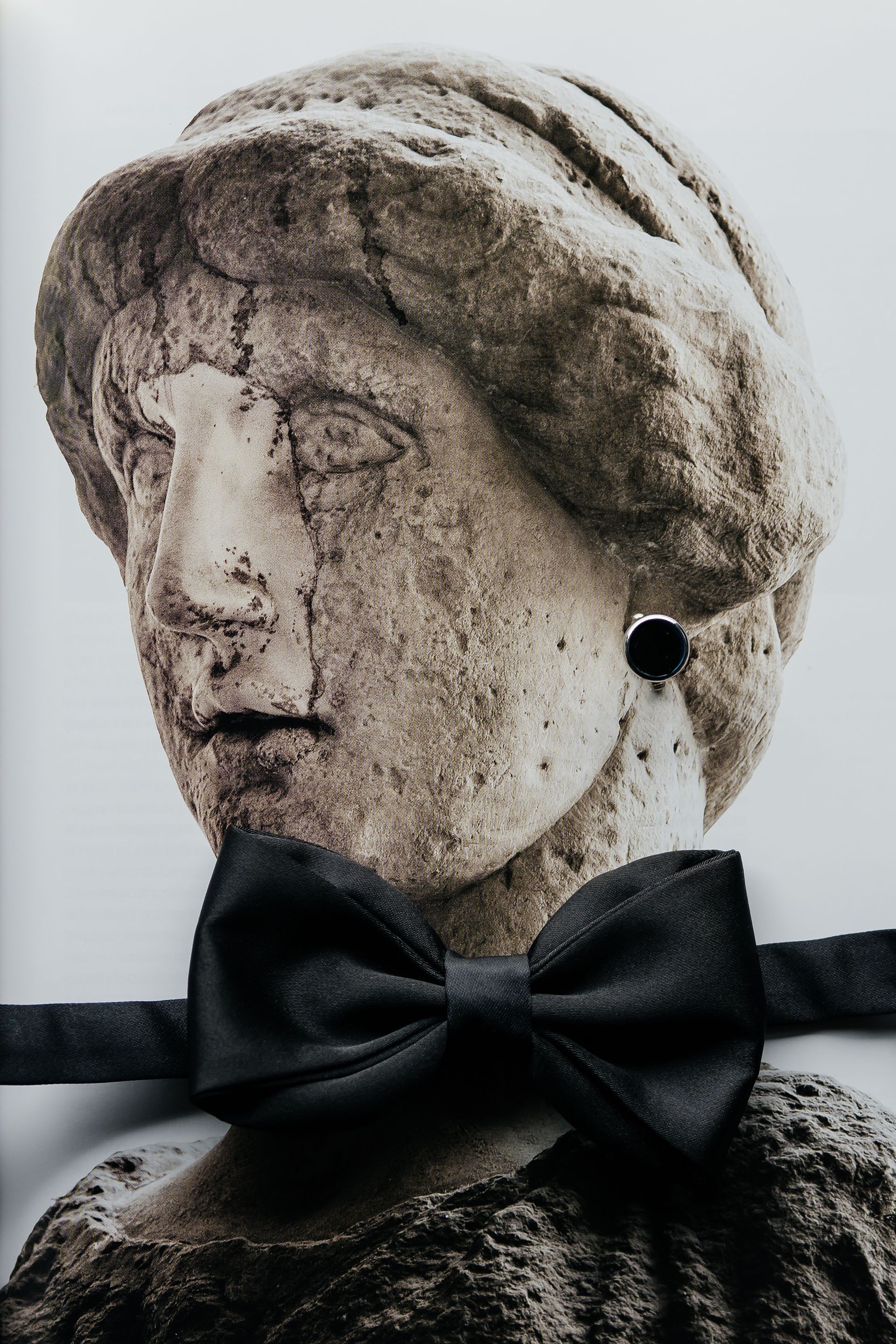 Editorial wedding detail with classical statue and black bow tie in Italy luxury wedding setting