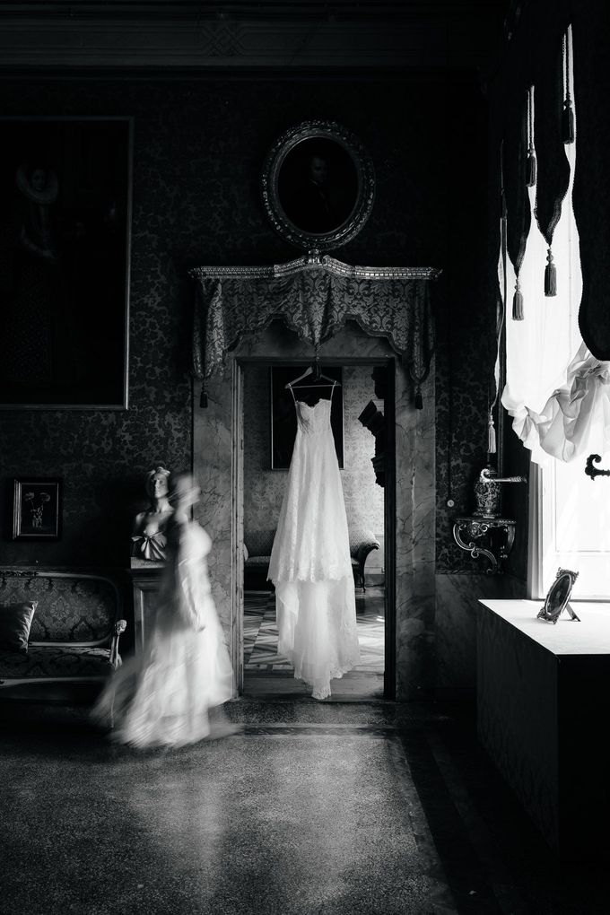 Wedding dress hanging in historic Italian villa captured in timeless editorial wedding photography