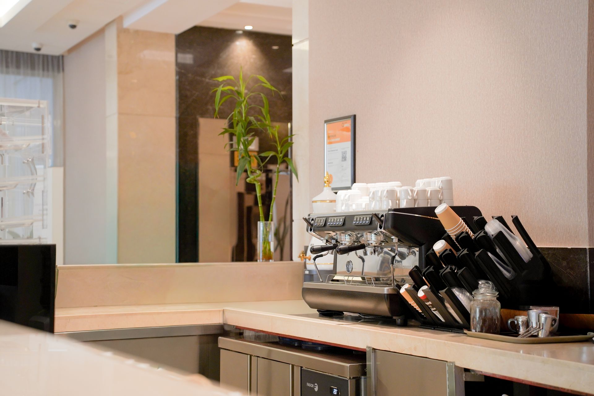 Coffee station with cups, espresso machine, and knives on a countertop in a modern room