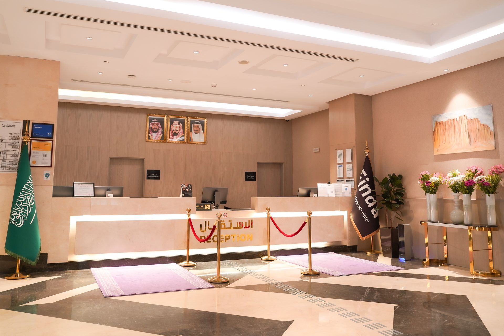 Hotel reception desk with warm lighting, marble floor, and roped stanchions in a modern lobby.