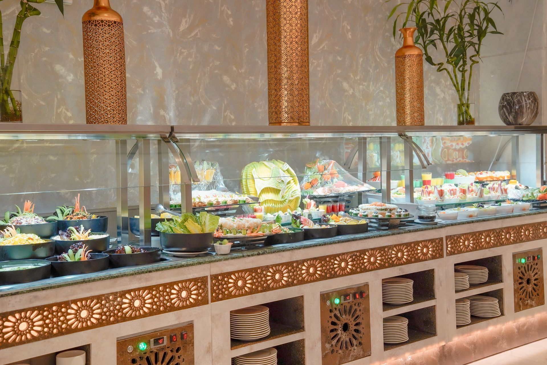 Buffet counter with glass cases of assorted dishes and decorative woven lanterns above