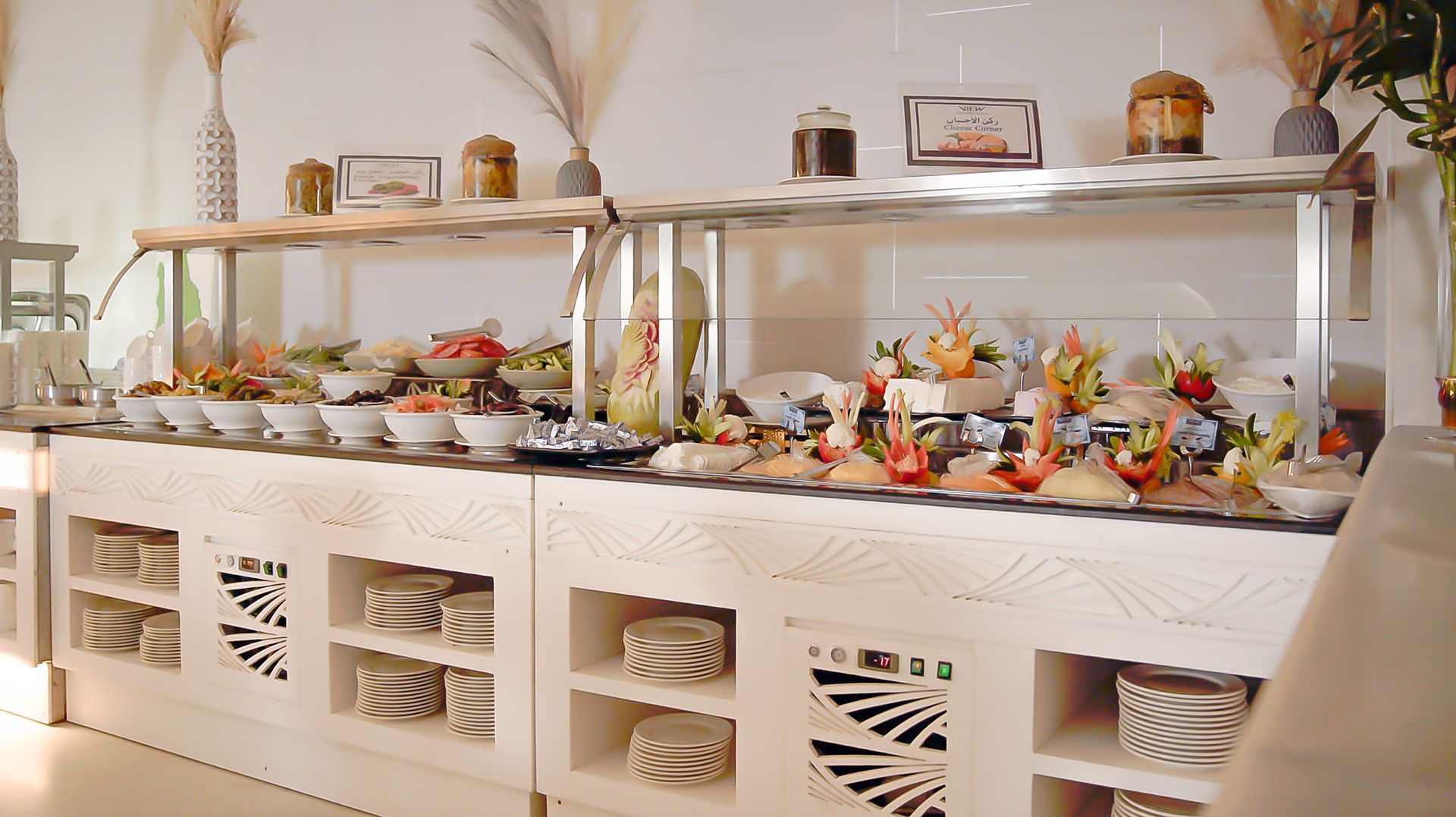 Buffet table with assorted desserts and decorative flowers in a bright dining room