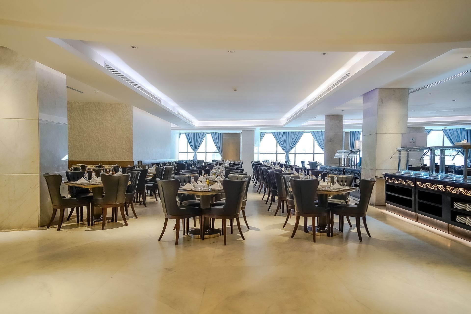 Modern restaurant dining room with tables, chairs, and soft lighting