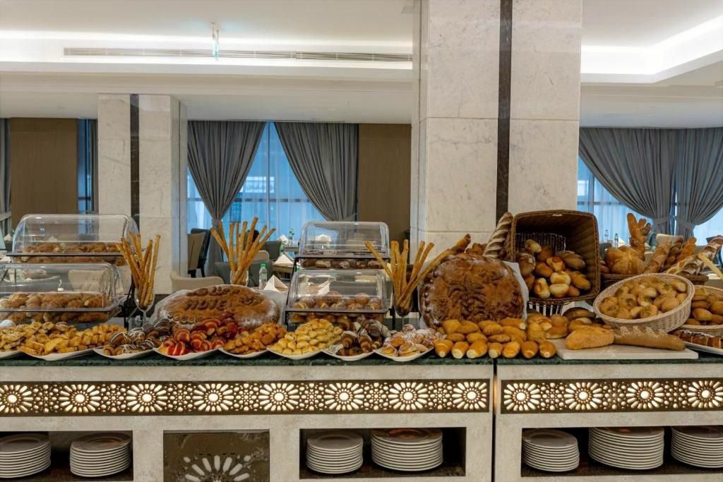 Buffet table with assorted pastries and bread in a formal dining room with mirrored walls.