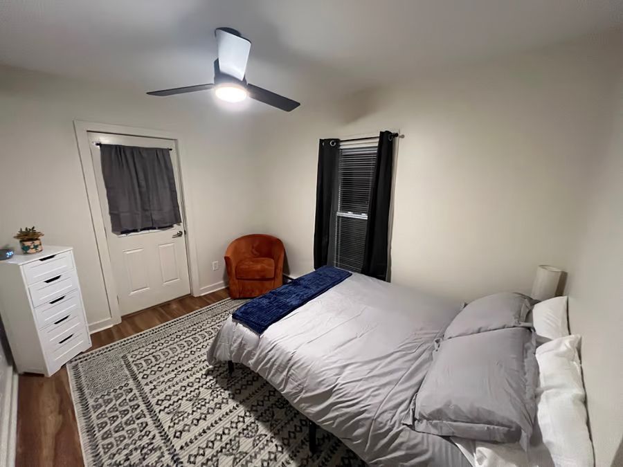 A living room with a couch , rug and ceiling fan.