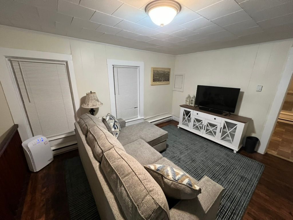 A living room with a couch and a flat screen tv.