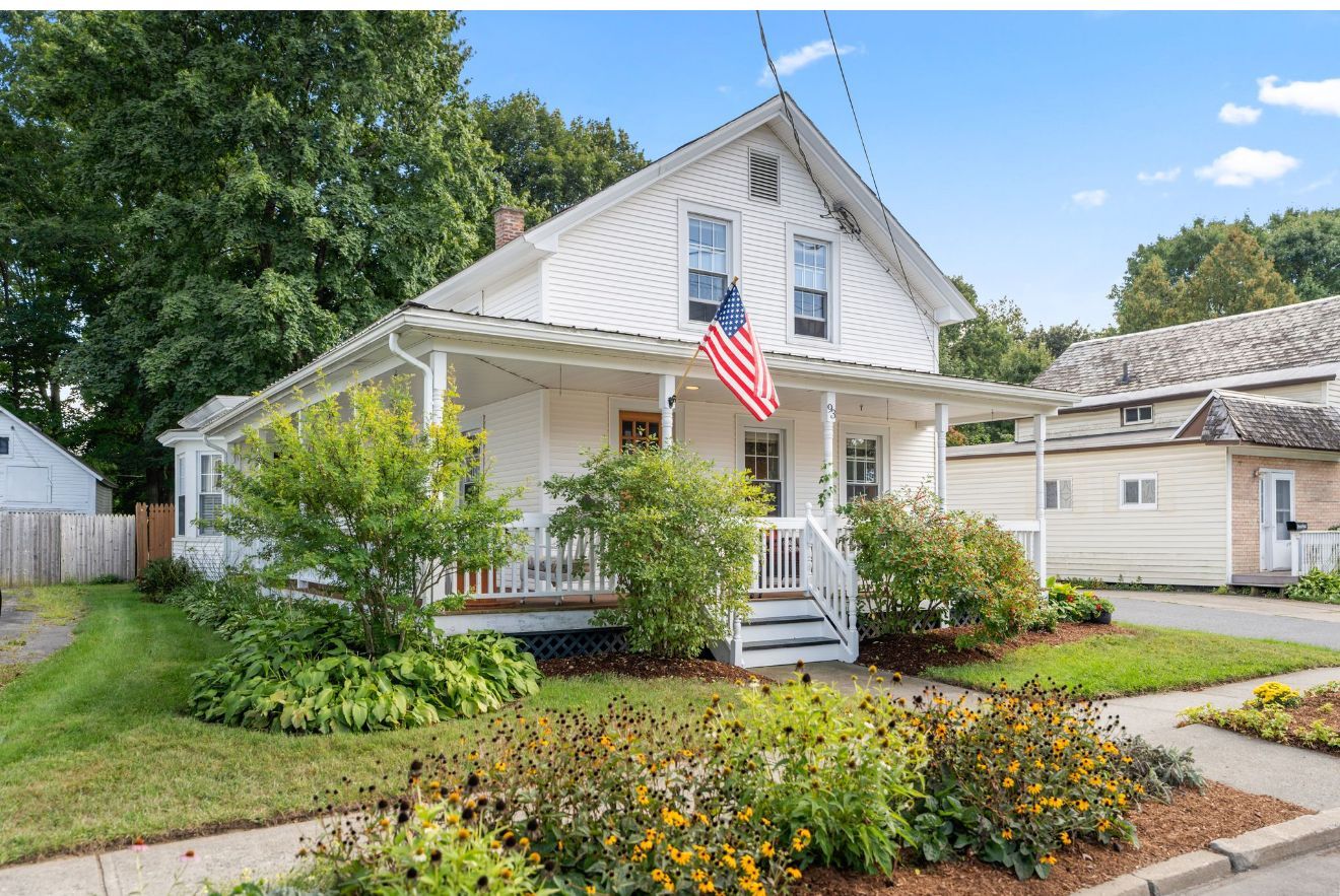 Hallway with hardwood floors, gray walls, and a wooden desk.