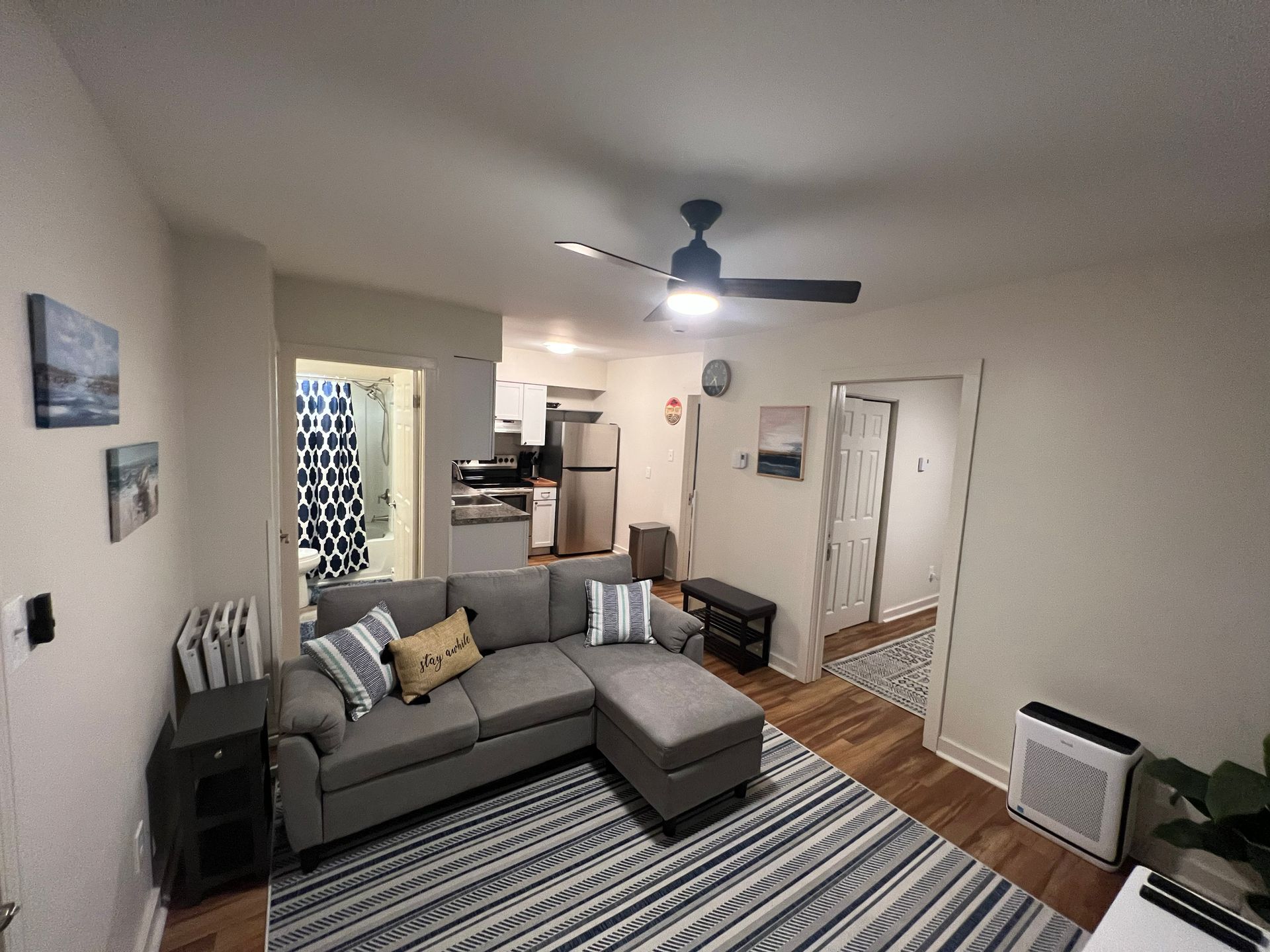 A man in a suit and blue shirt is leaning against a wall.