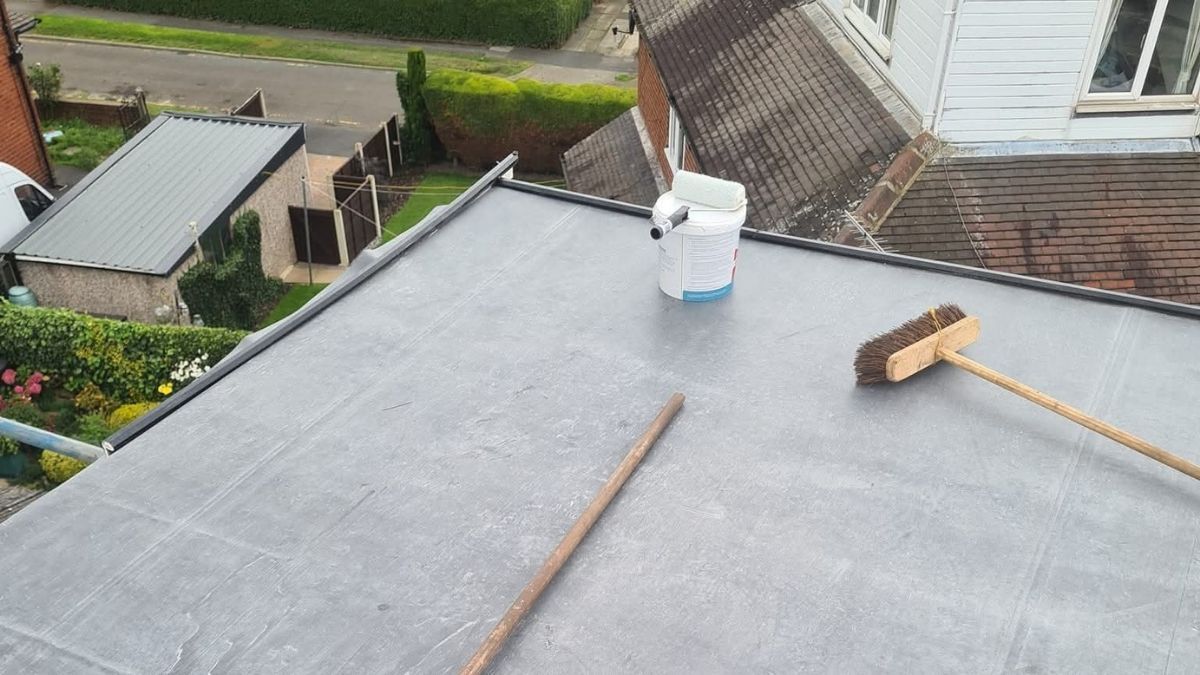 White resin paths split into two around a raised flowerbed, bordered by light-coloured stone walls.