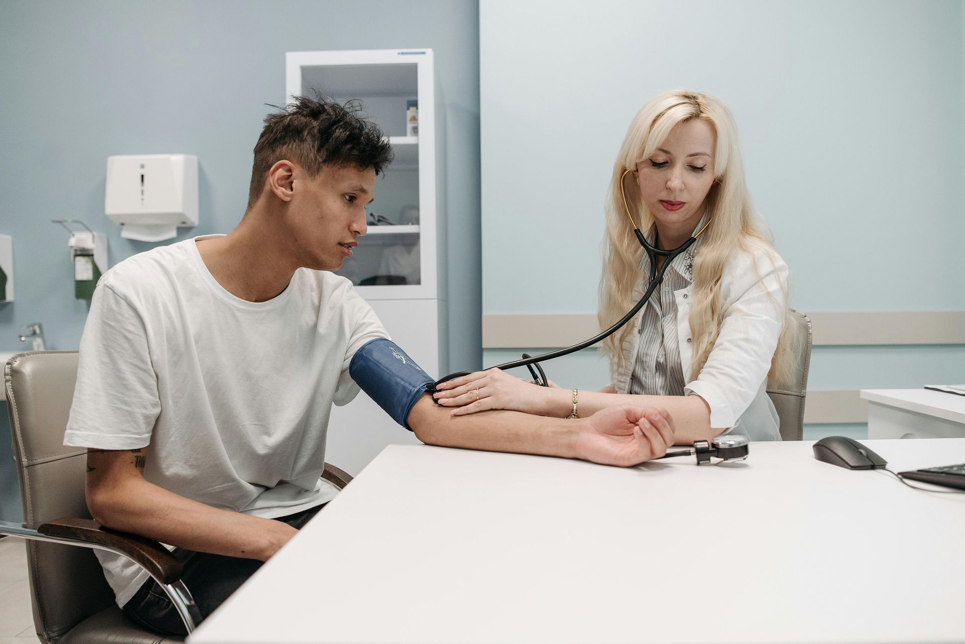 man getting his blood pressure taken by a doctor