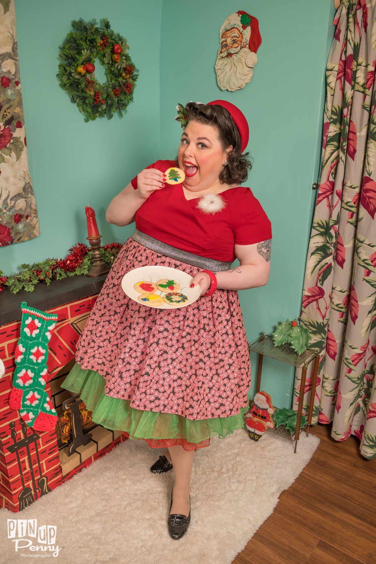 a woman is standing in front of a fireplace holding a plate of food .