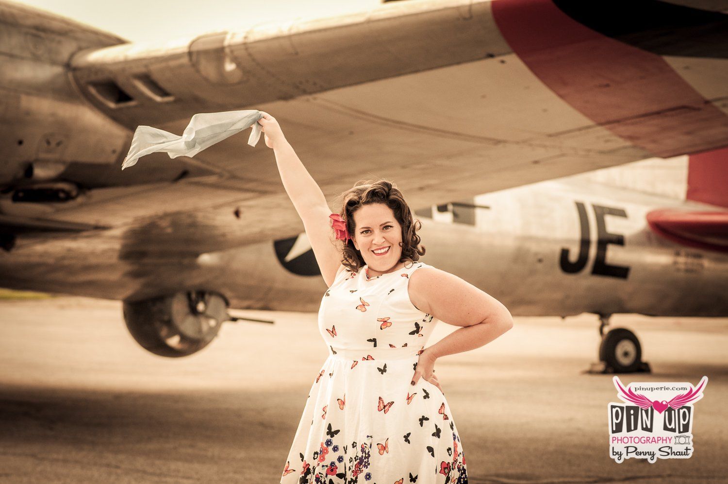 a woman in a dress is standing in front of a plane with the letters je on it .