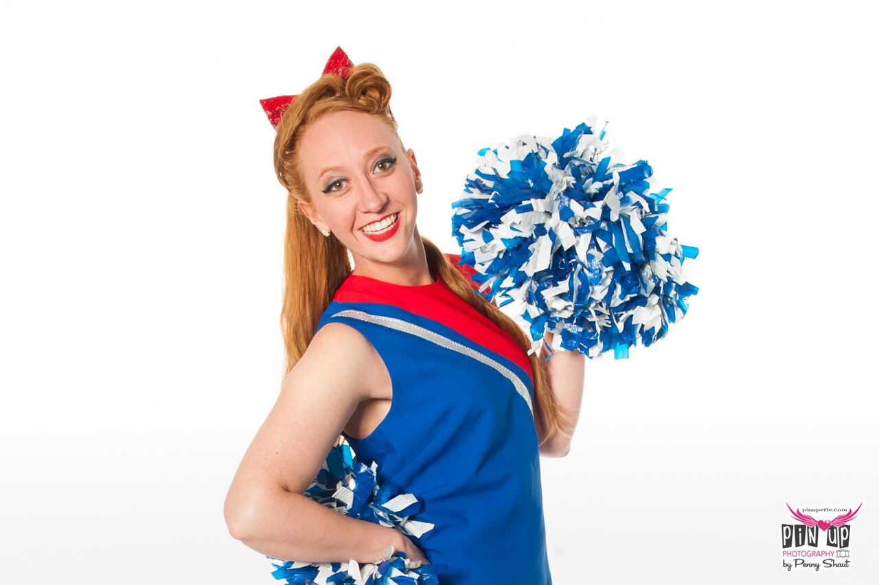 a cheerleader in a blue and red uniform is holding pom poms