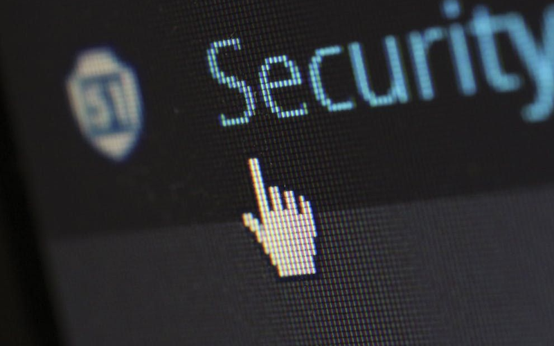 Close-up of a computer security webpage with a hand cursor pointing at the word ‘Security’.”