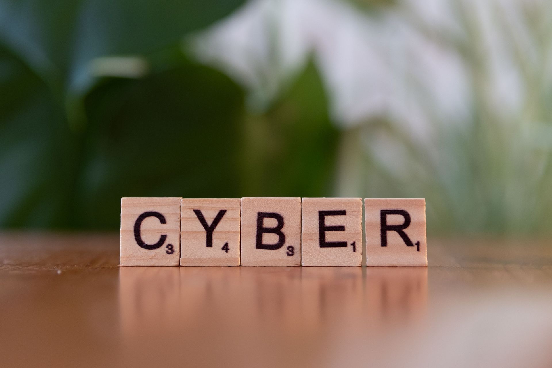 Cybersecurity service provider concept image with letter blocks spelling “CYBER” on a desk