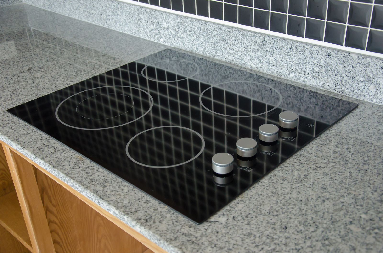 A close up of a gas stove with blue flames coming out of it.