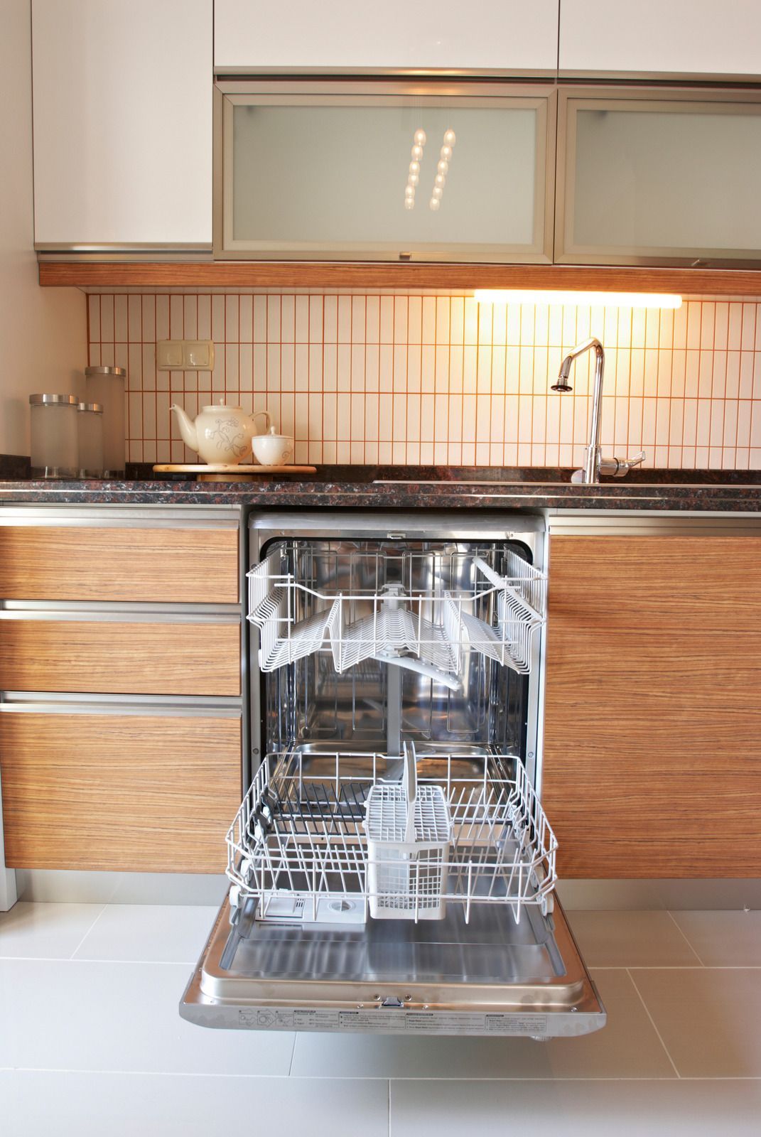 A dishwasher is open in a kitchen with wooden cabinets.
