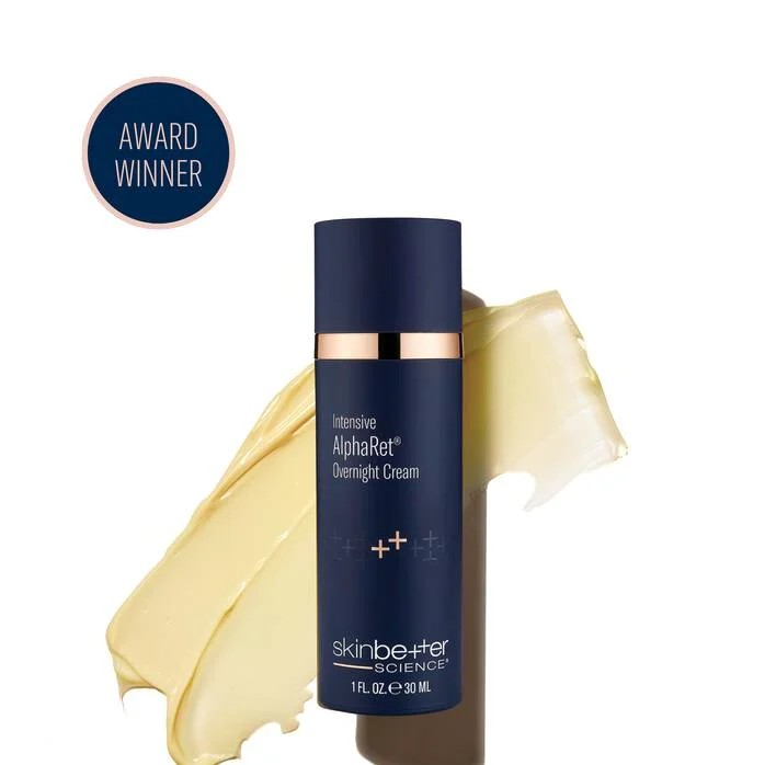 Dark blue skincare cream bottle with gold accents next to a smear of cream; an award winner seal is at the top left.