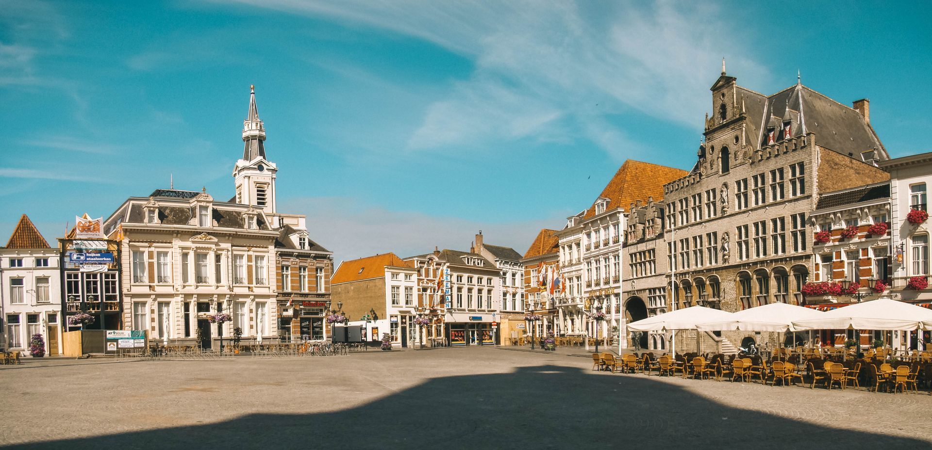 Een stadsplein vol met gebouwen en parasols.