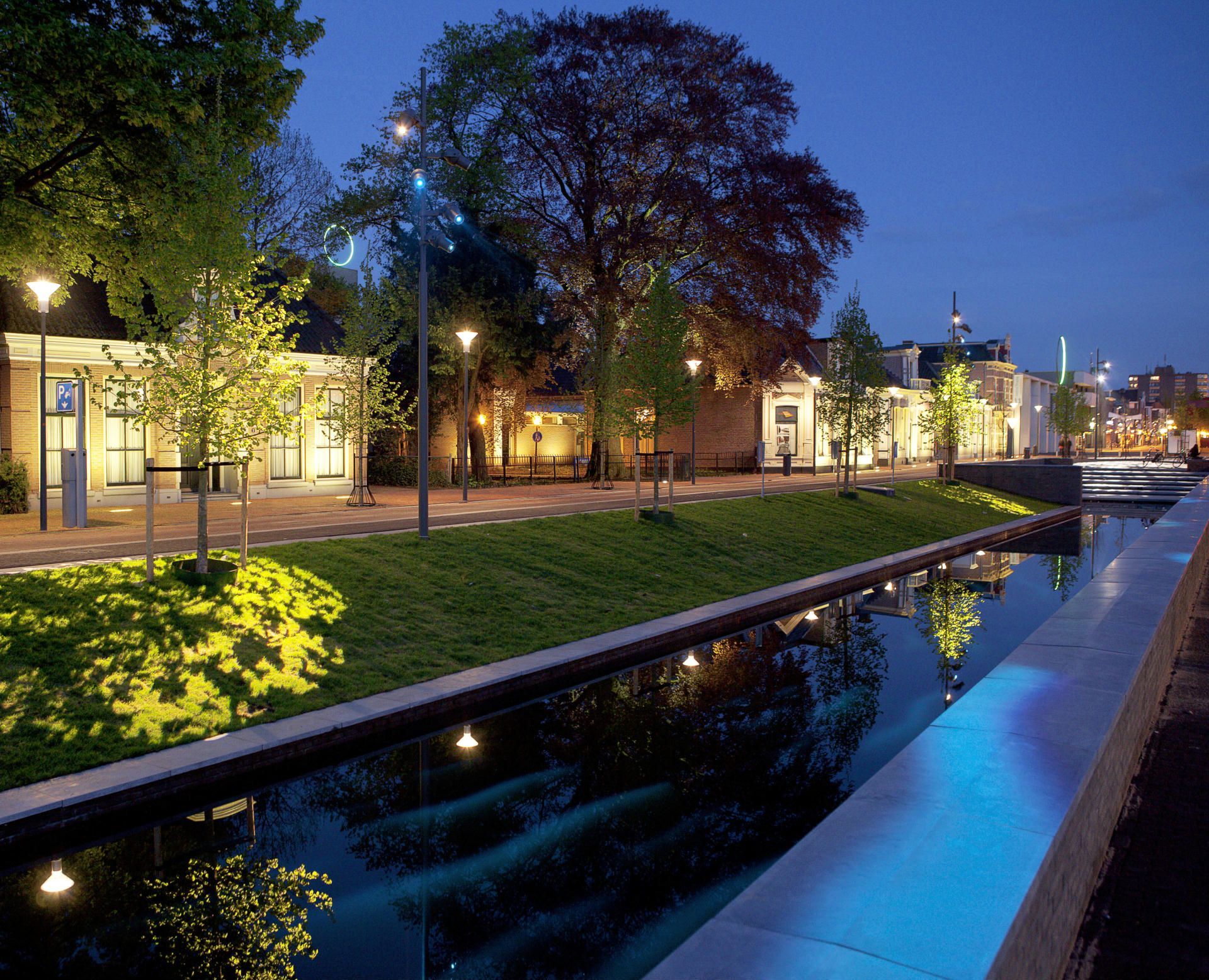 Een rij gebouwen langs een rivier 's nachts