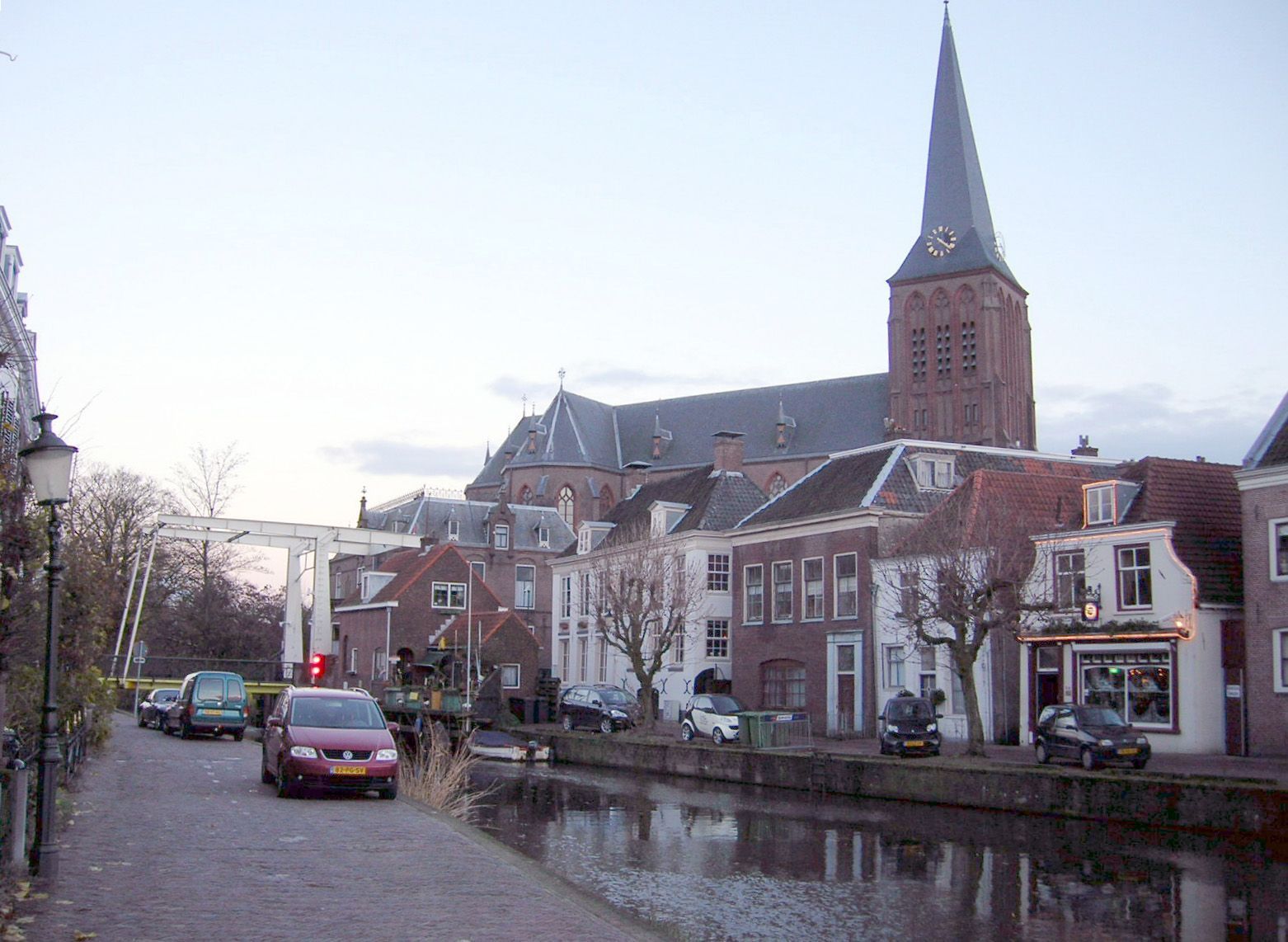 Een rij auto's staat geparkeerd voor een kerk