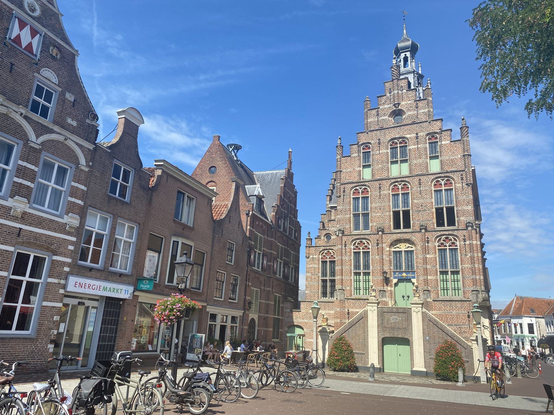 Een groep fietsen staat geparkeerd voor een groot gebouw.