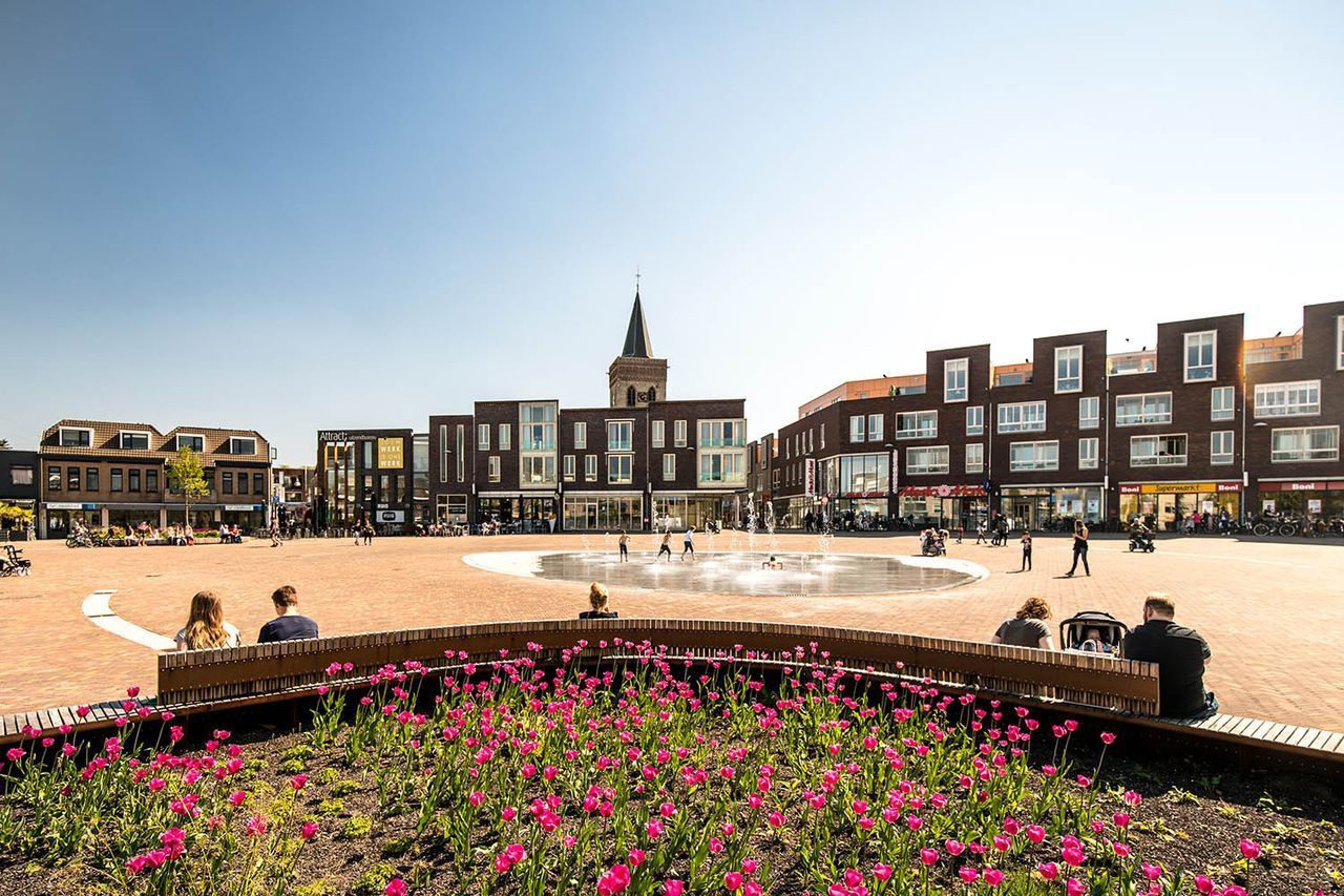 Een stadsplein met een fontein in het midden