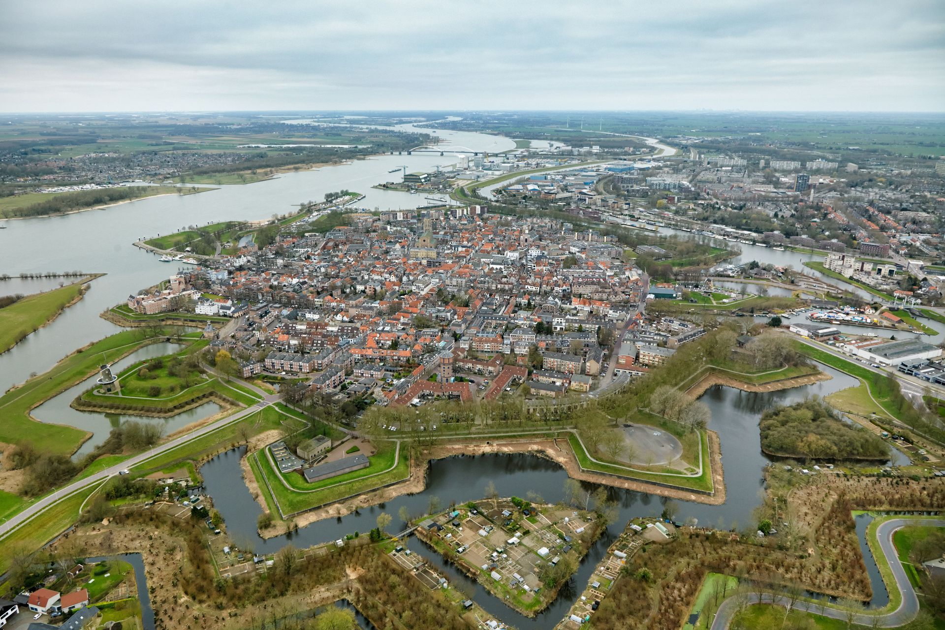 Een luchtfoto van een stad omgeven door water en een rivier.