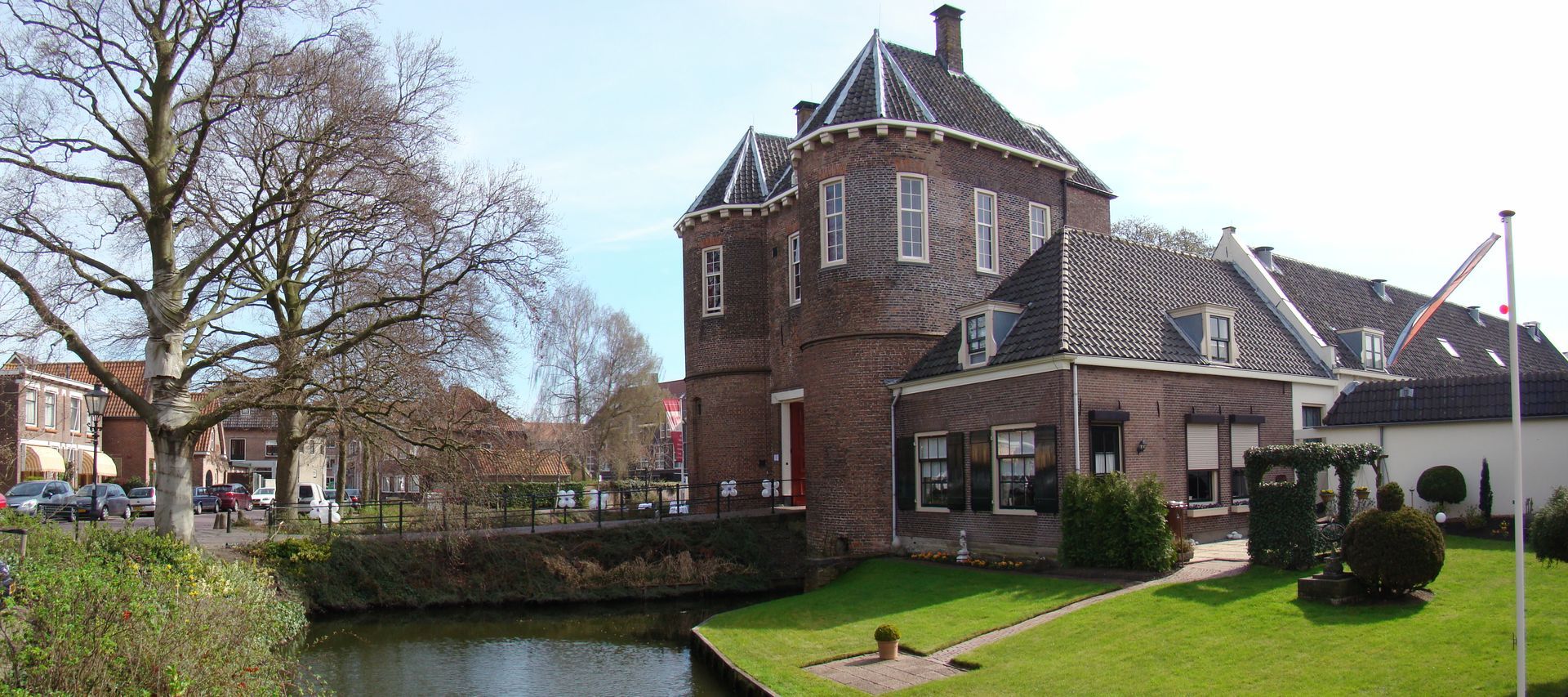 Een groot bakstenen gebouw met een rivier ervoor