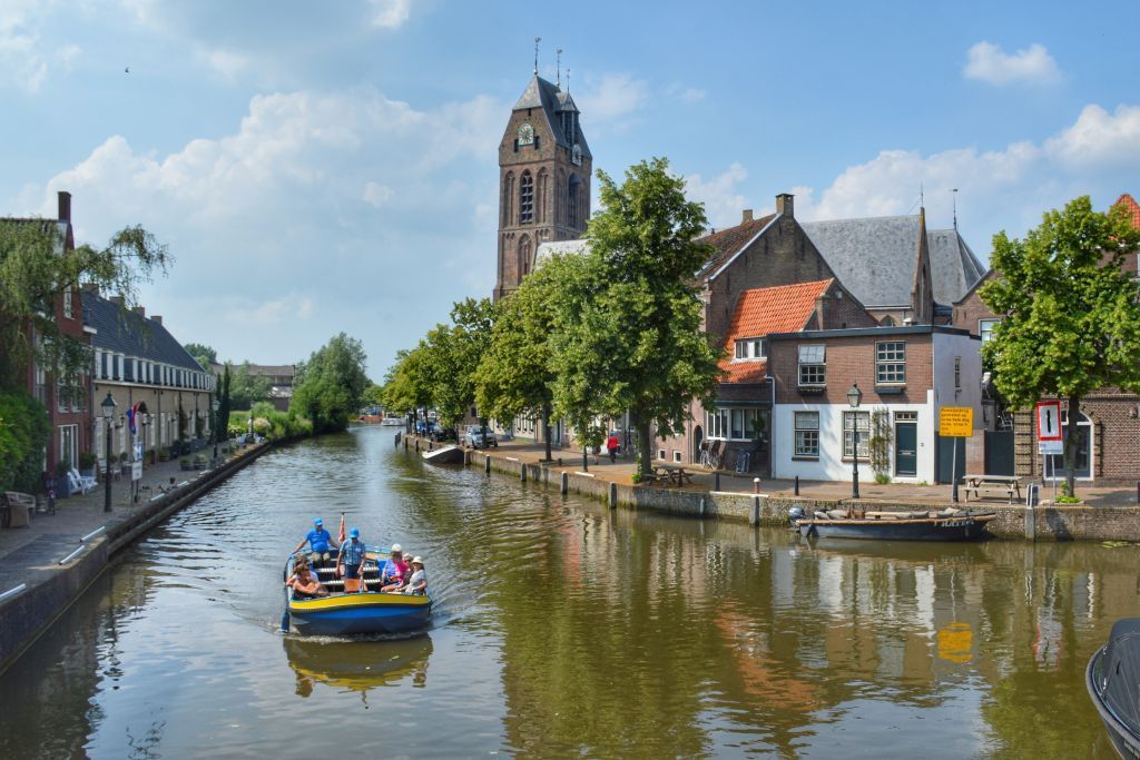 Een boot vaart over de rivier in een klein stadje.