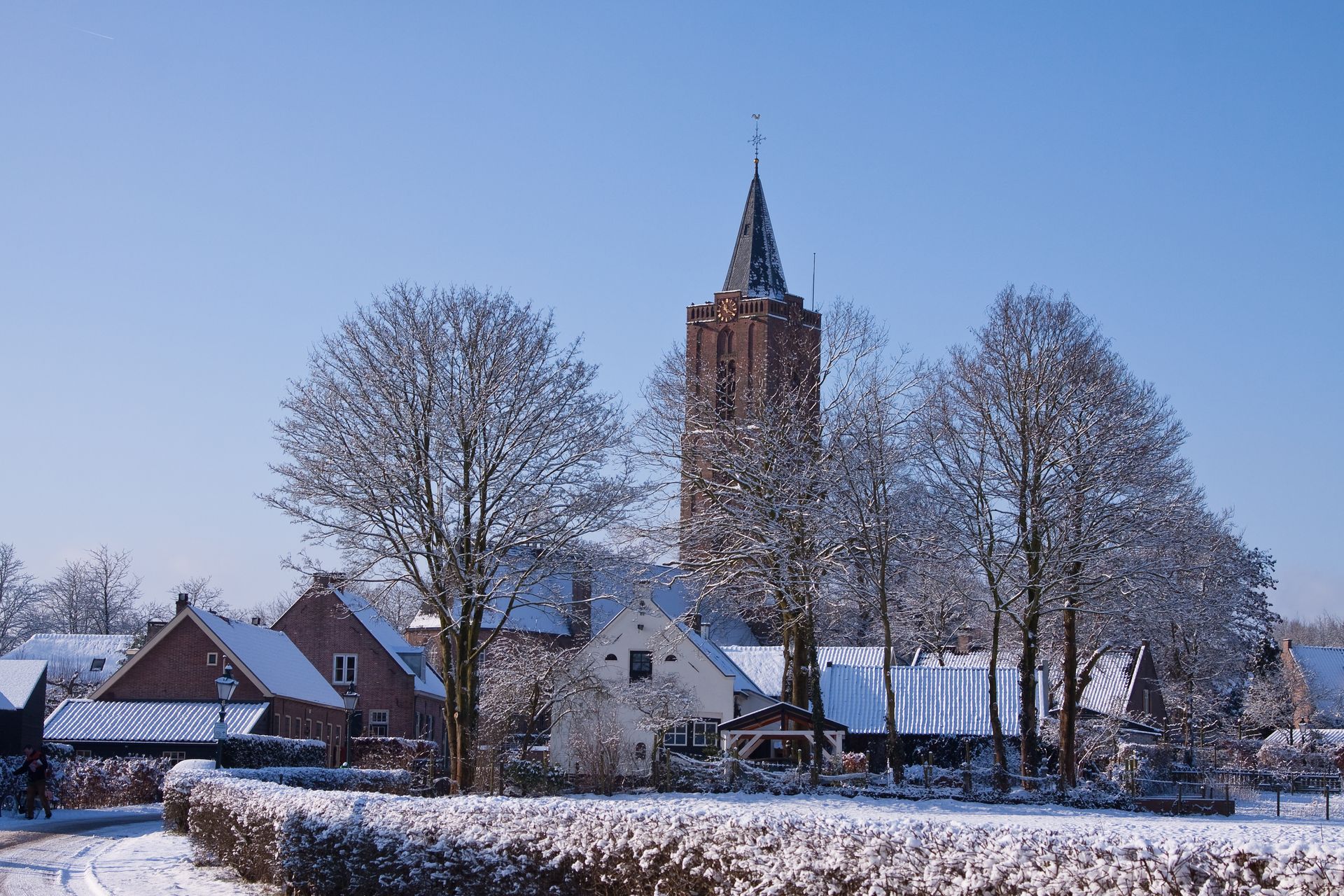 Een besneeuwd dorp met een kerk op de achtergrond