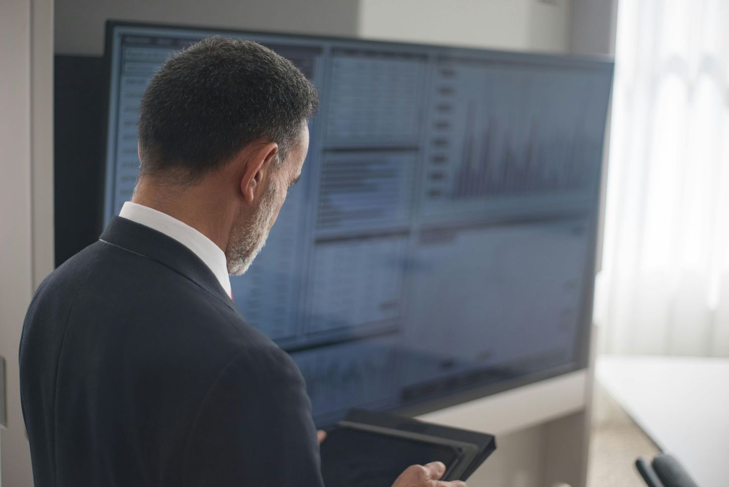 Person viewing data on a large monitor in a bright office