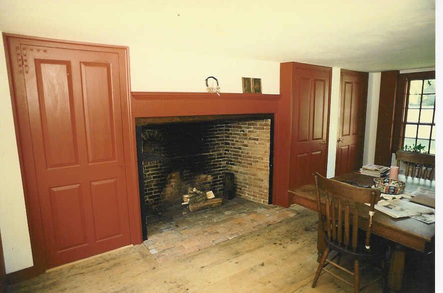 A dining room with a fireplace and a table and chairs