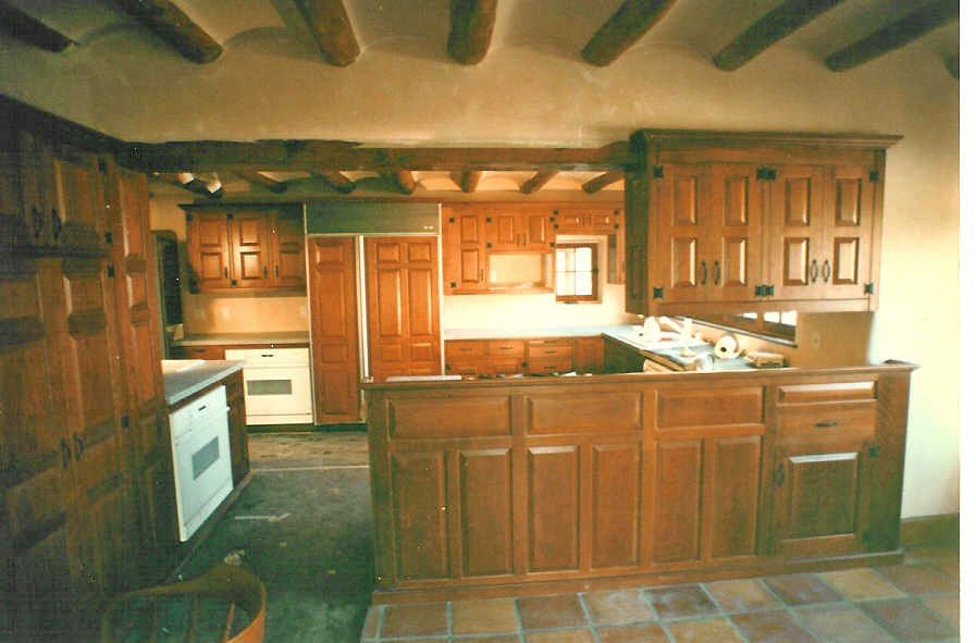 A kitchen with wooden cabinets and a tiled floor