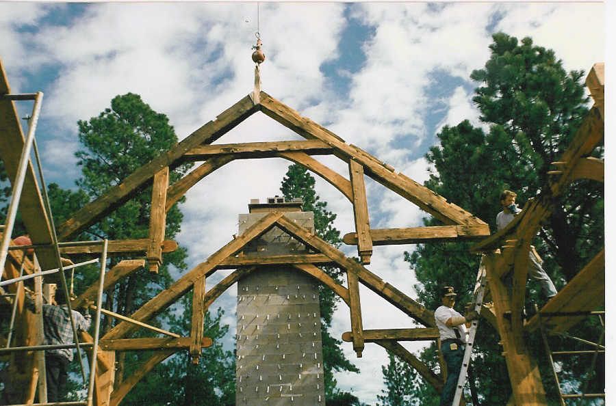 A wooden structure is being built with trees in the background