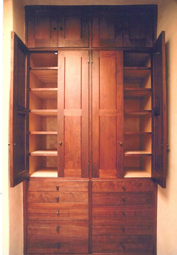 A wooden cabinet with the doors open and shelves