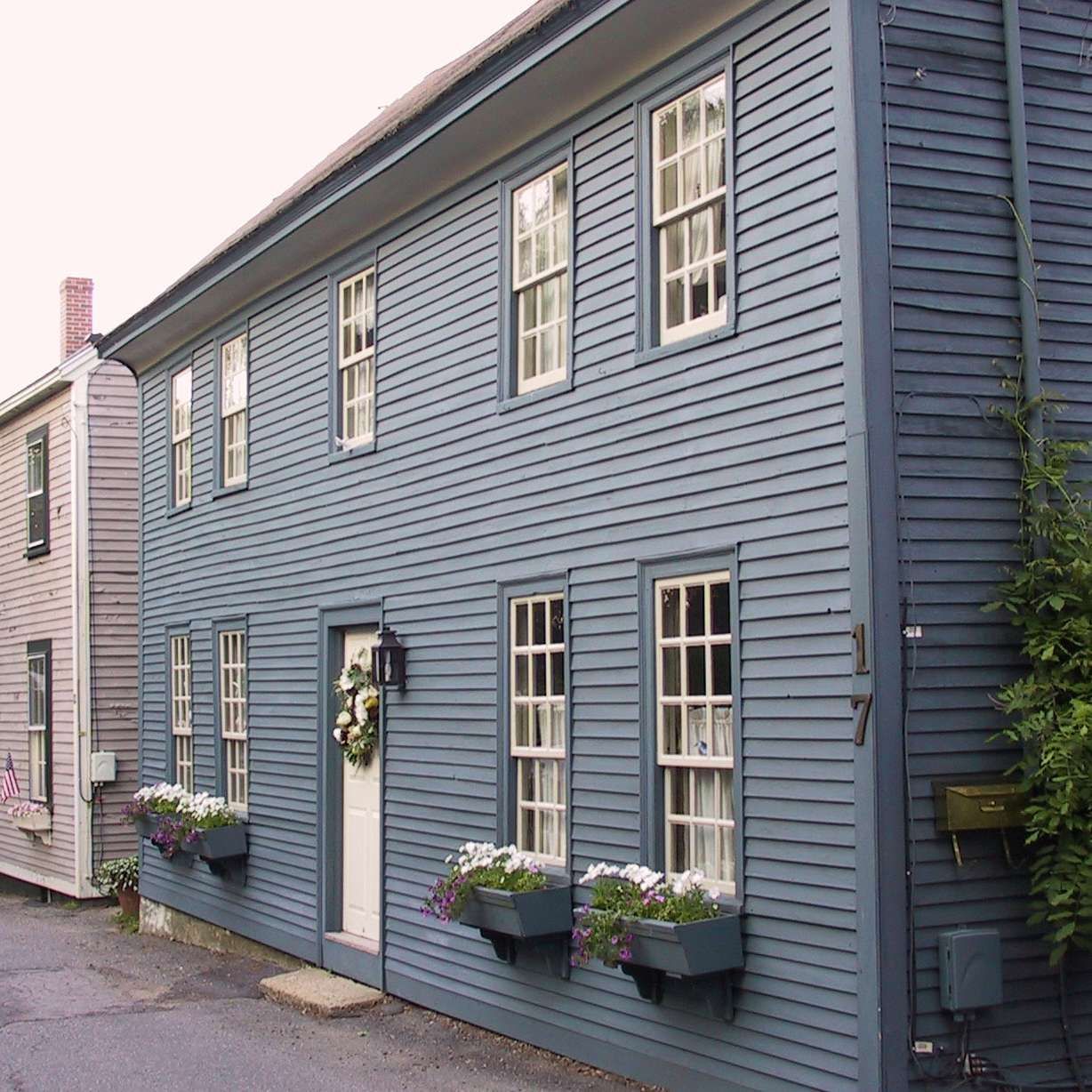 A blue house with a mailbox on the side of it
