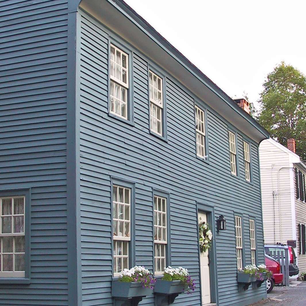 A blue building with a lot of windows and flowers in front of it