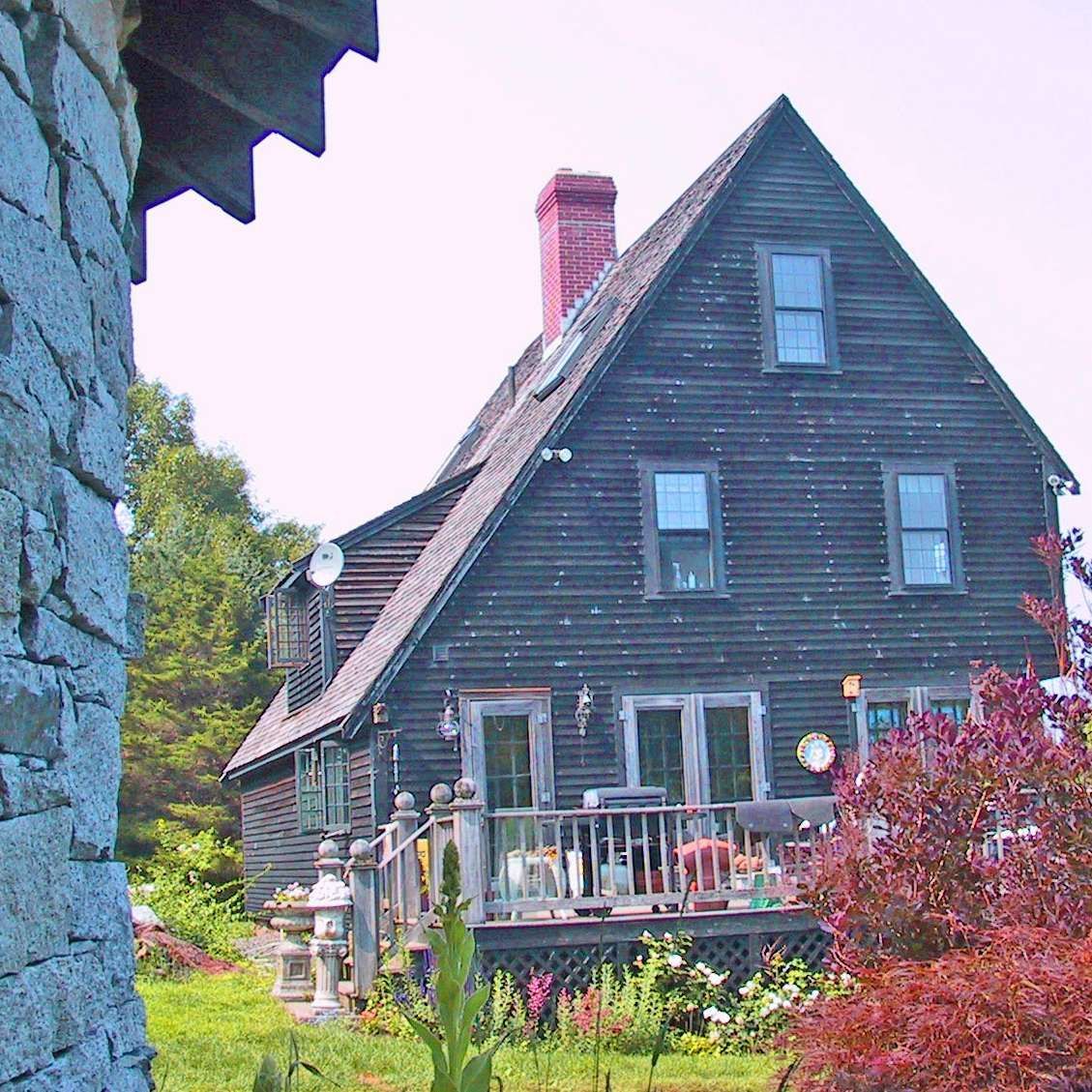A large wooden house with a brick chimney on the roof