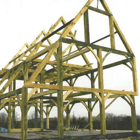A large wooden structure under construction with a white background