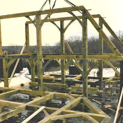 A large wooden structure is being built with a crane.