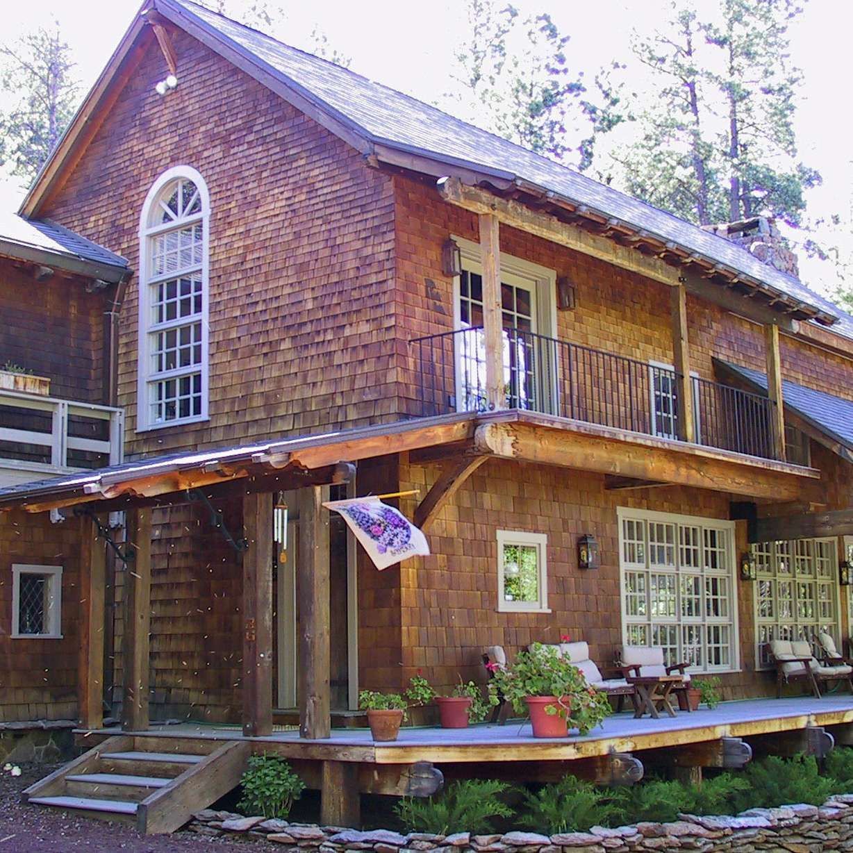 A large wooden house with a balcony and a flag on the porch