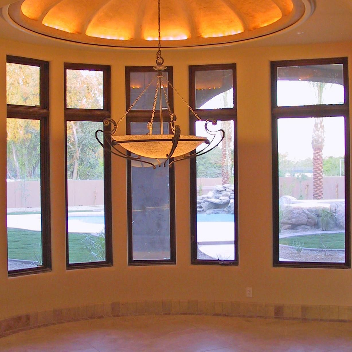 A room with lots of windows and a chandelier hanging from the ceiling